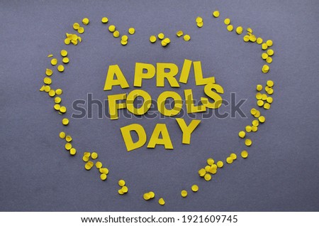 Image caption April Fools' Day yellow inside the heart of confetti on a grey background. High quality photo