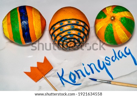 Koningsdag or King's Day is a national holiday in the Kingdom of the Netherlands. Painted oranges and the flag of the Netherlands on a white background