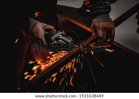 A man is cutting iron with an electric machine
