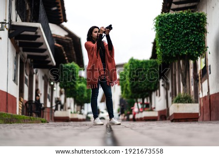 Mexican woman getting to know towns in Mexico. she has a camera in her hands and the shot is at floor level