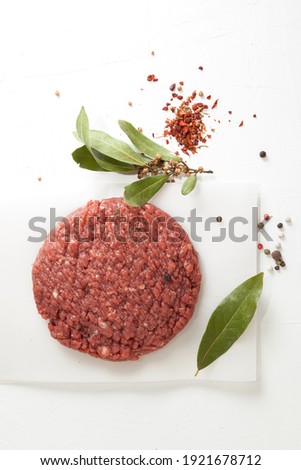 Homemade hamburger or Raw minced meat and spices on light background, top view.