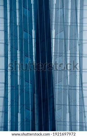 Fragment of glass and metal facade walls with reflection of neighbor skyscrapers. Commerical office buildings. Abstract modern business architecture. Irregular background with polygonal structure.