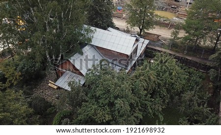 Aerial view of traditional summer russian village with old houses and green trees. Stock footage. Lush vegetation near residential cottages and construction site.