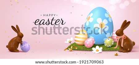 3d Easter banner with chocolate rabbits and beautiful painted eggs set on grass. Concept of Easter egg hunt or egg decorating art. Royalty-Free Stock Photo #1921709063