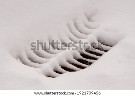 storm sewer road grate under the snow