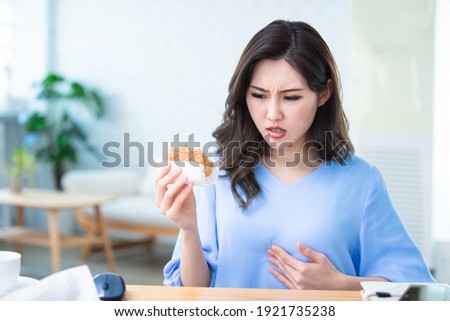 asian woman eat hamburger and has Gastroesophageal Reflux Disease Royalty-Free Stock Photo #1921735238