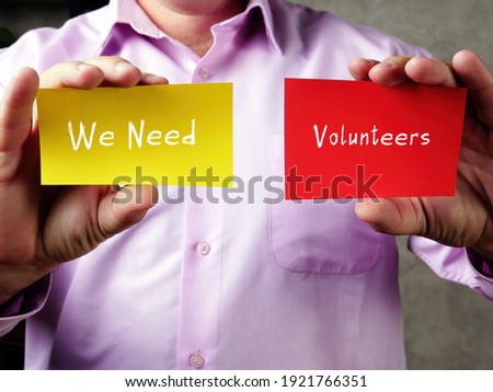 We Need Volunteers sign on the piece of paper.
