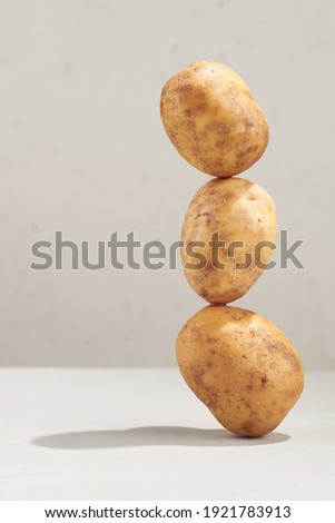 Whole potato balanced on a table.  Vertical photo with copy-space.