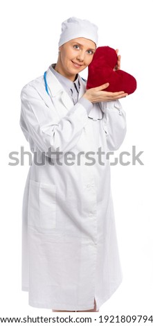 female doctor in white coat and hat. the medic holds a large soft heart, gently lovingly pressed her cheek to her heart. health care. cardiology, heart treatment. white background, isolated