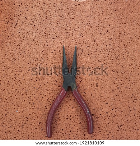 Long nose pliers on the brown colour