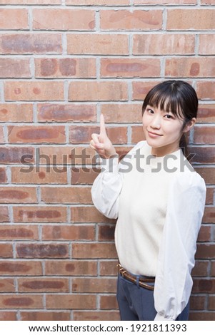 Woman standing with her index finger up  (gesture)