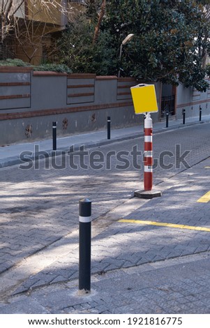 red traffic cones by pavement on road to block parking at street, yellow warning sign,