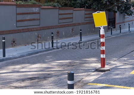 red traffic cones by pavement on road to block parking at street, yellow warning sign,