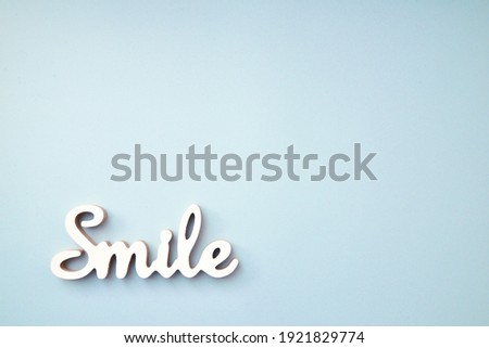 wooden smile text on light blue background. Text is in focus 