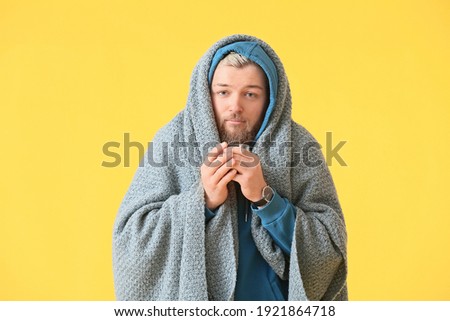 Sick young man with hot tea on color background