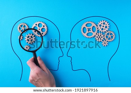 Human brain is made gear mechanism on blue background. The brain is viewed through a magnifying glass. Two different thought processes, concept of different thinking. Royalty-Free Stock Photo #1921897916