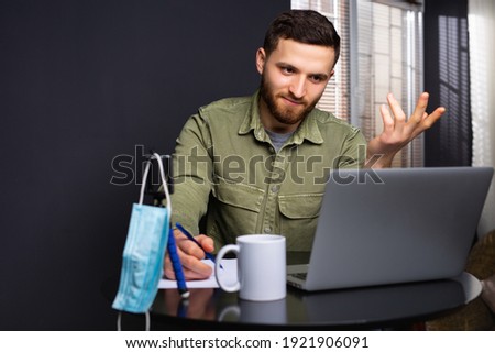 Photo of a perplexed young student who is studying in front of a laptop and is having difficulties. Low level of effectiveness of online learning. High quality photo