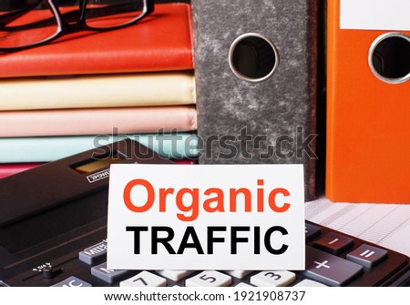 Next to the diaries and folders with documents on the calculator there is a white card with the inscription ORGANIC TRAFFIC
