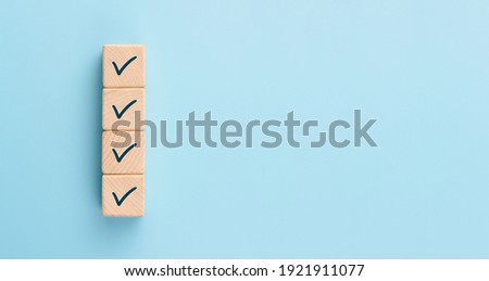 Checklist concept, Check mark on wooden blocks, blue background with copy space Royalty-Free Stock Photo #1921911077
