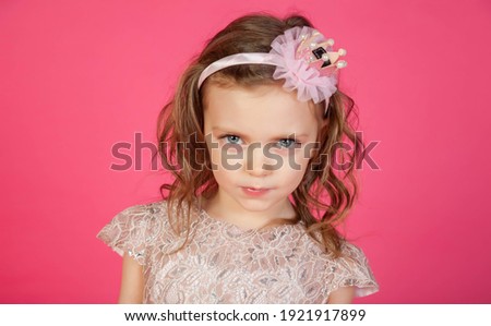 Portrait 5-6 year old girl in dress on pink isolated background looks at camera. Concept Playing and Children Recreation. Little child in casual clothes posing and showing emotions. Copy space