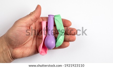 Three colored balloons in a man's hand. white background 