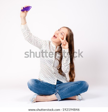 Happy young woman taking a selfie using her smartphone