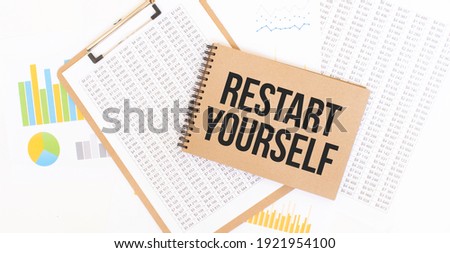 Text Restart Yourself on brown paper notepad on the table with diagram. Business concept