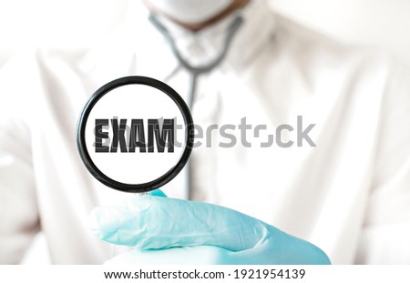 Doctor holding a stethoscope with text EXAM, medical concept