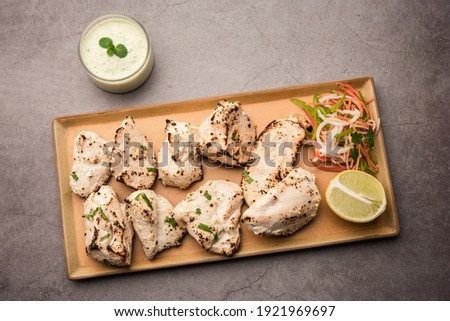 Indian Afghani chicken Malai Tikka is a grilled Murgh creamy kabab served with fresh salad Royalty-Free Stock Photo #1921969697