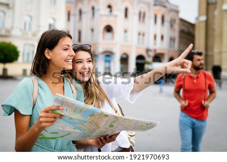 Happy friends enjoying sightseeing tour in the city. Royalty-Free Stock Photo #1921970693