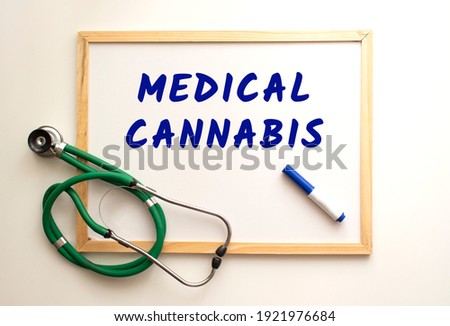 The text MEDICAL CANNABIS is written on a white office board with a marker. Nearby is a stethoscope. Medical concept.
