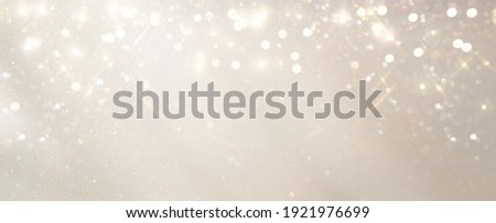 glitter vintage lights background. silver, gold and white. de-focused