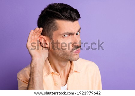Photo of curious evil guy arm ear eavesdropping listen wear beige shirt isolated purple color background