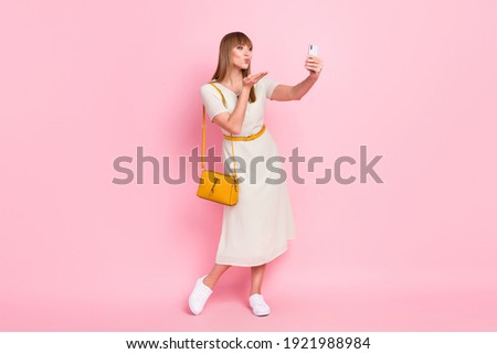 Full length body size view of attractive flirty girl taking selfie sending air kiss isolated over pink pastel color background