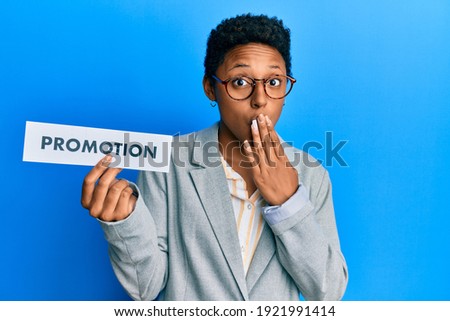 Young african american girl holding sale poster covering mouth with hand, shocked and afraid for mistake. surprised expression 