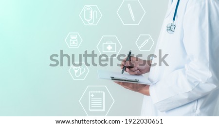 Concept of treating patients in the digital age The male doctor was writing down some information in his records. , stethoscope on his neck, medical icon