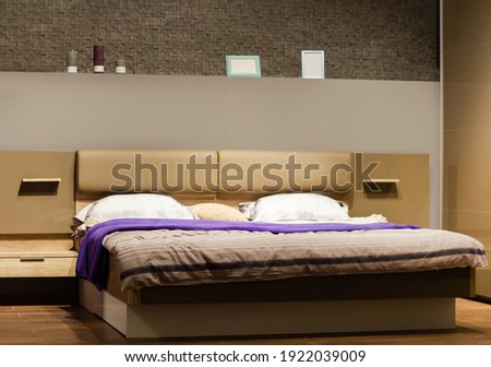 Photo of bedroom with bed, furtinure, shelves and accessories.