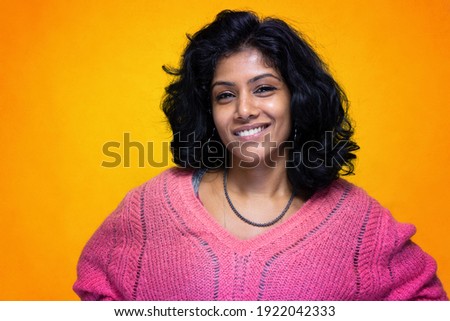 Beautiful Sri Lanka girl poses standing with yellow bright background- Young woman smiles