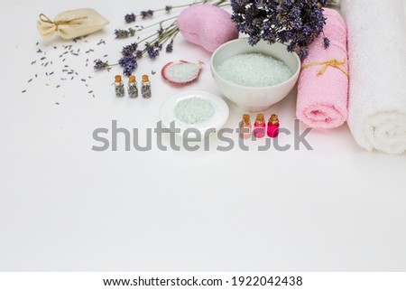 Spa cosmetics sea salt and towels,  aroma oils and dry lavender on a white background with a copy of the space