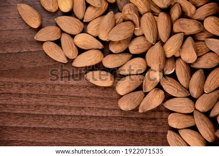 Pile of almonds on the wooden table top view stock images. Almond nuts on a wooden background images