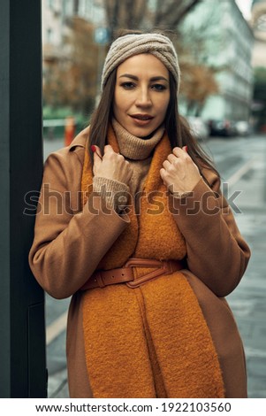 The girl poses near a street post. Walks and entertainment, photo session in the city