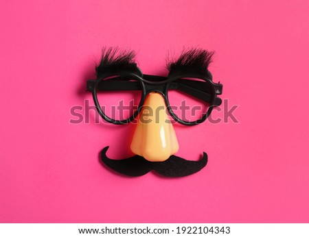 Funny glasses on pink background, top view Royalty-Free Stock Photo #1922104343