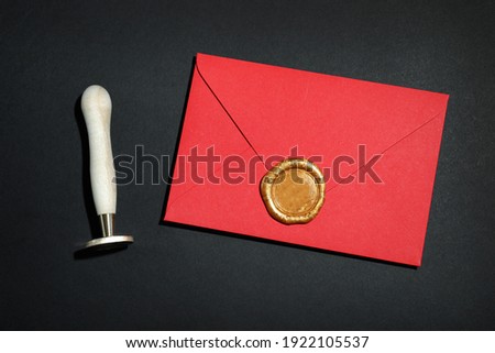 Envelope with wax seal and stamp on black background, flat lay Royalty-Free Stock Photo #1922105537