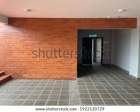 Beautiful facing bricks wall. Translation signage above the door mean exit