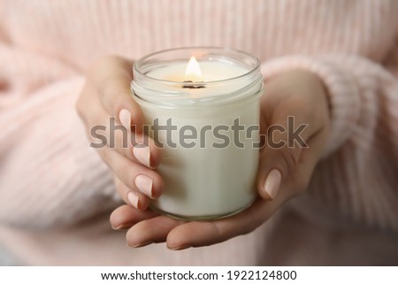 Woman holding burning candle with wooden wick, closeup Royalty-Free Stock Photo #1922124800