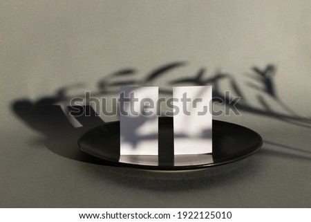 Blank business cards on grey background with shadows of money tree. Mockup. Good for text and logo