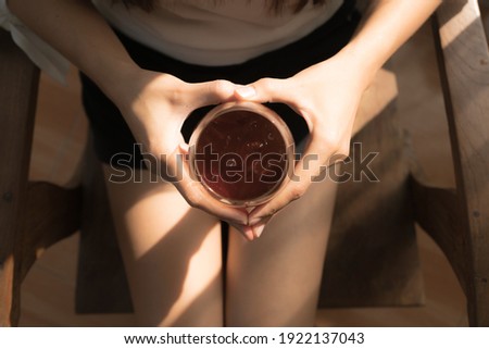 Close up Cup of coffee.Female hands holding a cup of coffee cup with heart shaped.
