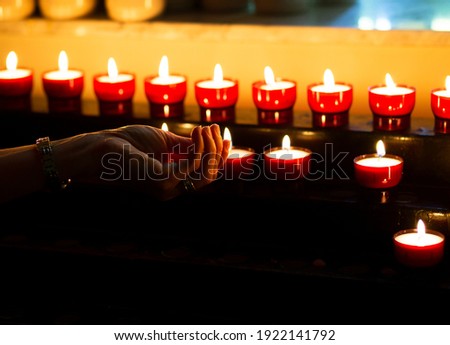 Female hand and lit candles, Antwerp, Belgium