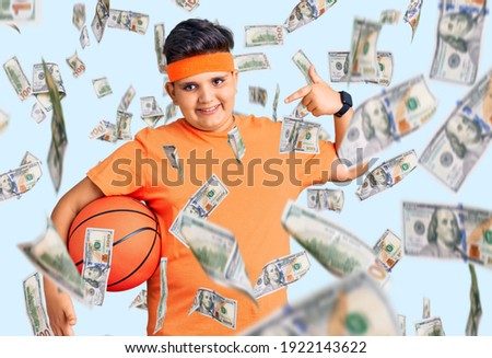 Little boy kid holding basketball ball pointing finger to one self smiling happy and proud