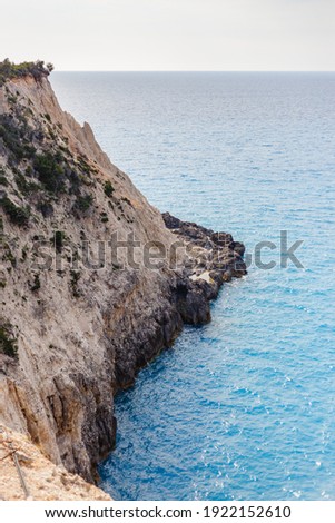 A vertical shot of boundless lagoon sea waters washing the cliff